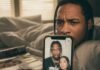 Is Travis Scott Cheating? The Viral Photo That’s Raising Eyebrows A person in bed squints at a phone screen displaying a blurry image of Travis Scott and a woman, with a magazine nearby.