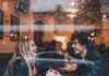 Sabrina Carpenter x Joshua Bassett: Back Together or Just PR? "Rainy window view of a couple holding hands in a cafe, smiling at each other."